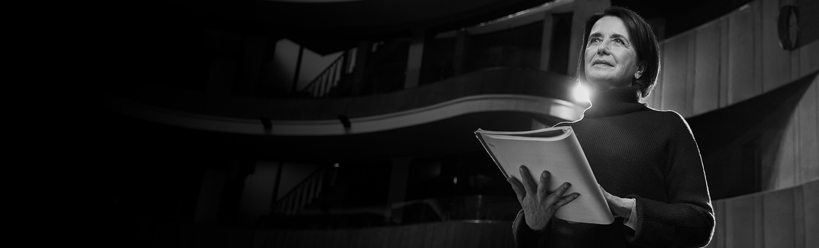 Donna legge un copione a teatro.